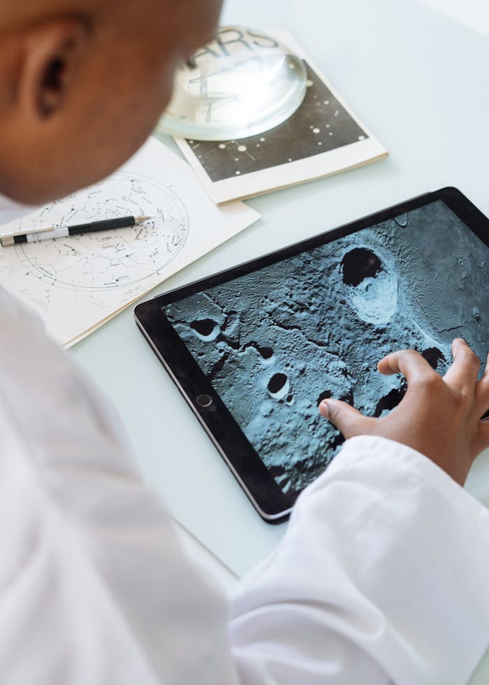 A student examines lunar craters on a tablet, embracing digital astronomy indoors.